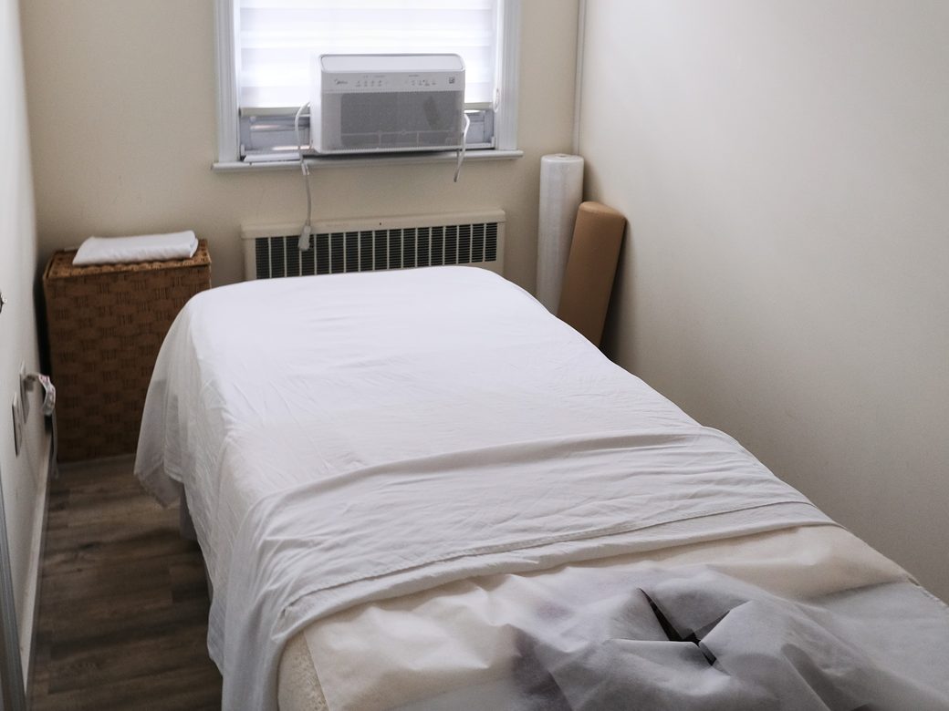 A treatment room with a prepared table beside a window