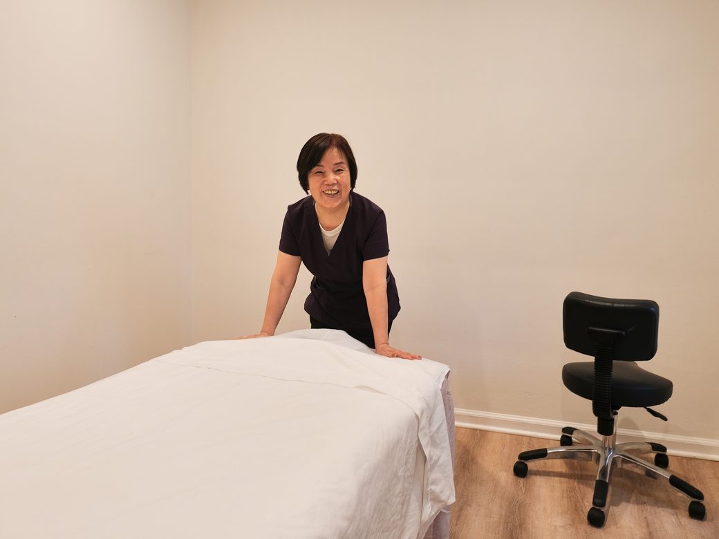 A practitioner beside a prepared massage table at Haram